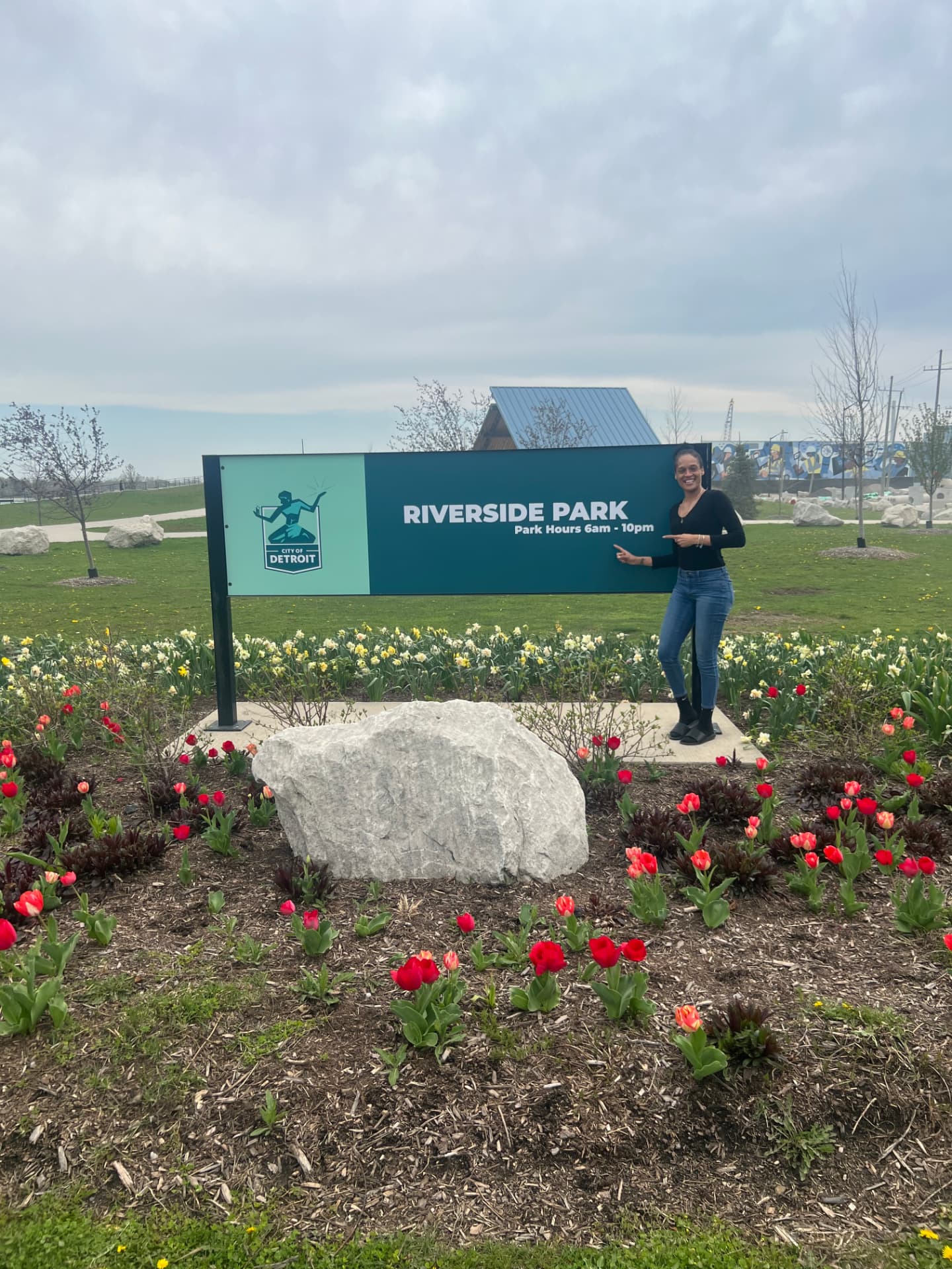 Lisette Gombs standing beside the Riverside Park sign in Detroit